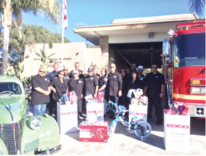 Members of Duke's Car Club with fire station 49 crew with donated toys. These toys will be distributed to children in the local community who might otherwise not have a merry Christmas. The group worked with Pastor Jack Miranda of the Living Faith Church in La Mirada.