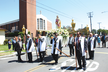 Leaders of the Artesia DES Community carry the statue of the Blessed Mother down Clarkdale Avenue during last weekend’s annual celebration. Photo by Randy Economy 