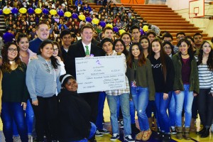 Brian Helleland, executive vice president and chief operation officer of St. Jude Medical Center in Fullerton, accepts a check for $1,520.17 from Norwalk High School students during the school’s Charity for Charities fundraiser on Dec. 15. 